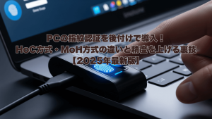 ノートPCにUSB接続された指紋認証デバイスに指が触れているアイキャッチ画像。「PCの指紋認証を後付けで導入！HoC方式・MoH方式の違いと精度を上げる裏技【2025年最新版】」という白文字のタイトルが画像中央に配置されている。